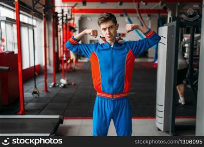 Strong male weightlifter doing exercise with dumbbells in gym. Bearded sportsman in sport club, healthy lifestyle