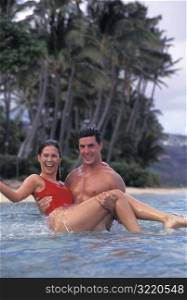 Strong Man Carrying Woman In Ocean