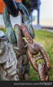Strong metal rusty metal chain a part of the anchor of the ship. Vertical view