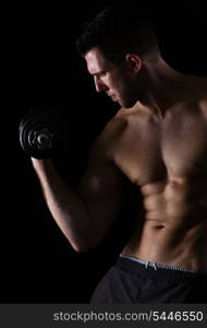 Strong muscular sports man rising dumbbell on black