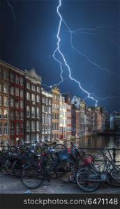Strong thunder and powerful flashes of lightning. Amsterdam central historical part of the city, canals and houses. Amsterdam central historical part of the city