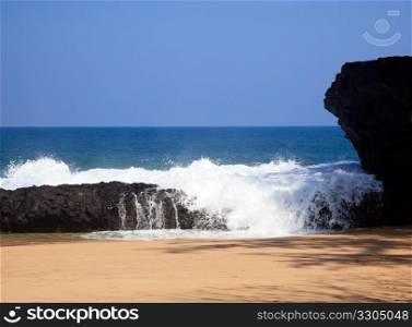 Strong waves crash over rocks on the beach at Lumahai on Kauai