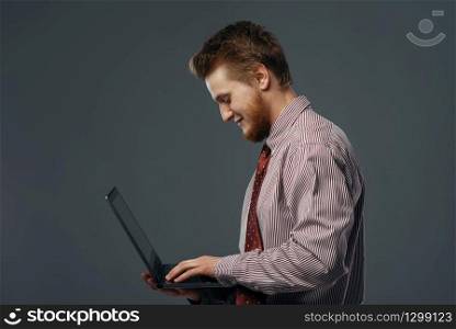 Strong wind blowing on man with laptop, funny emotion. Powerful air flow blows on businessman on black background. Strong wind blowing on man with laptop