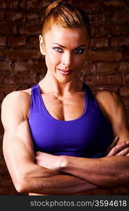 strong woman is posing against brick wall