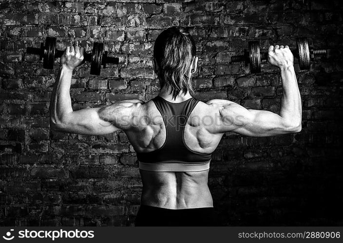 strong woman is training with barbells