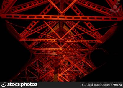 Structure of the Tokyo tower in the night, showing the concept of construction of the red tower with black background.