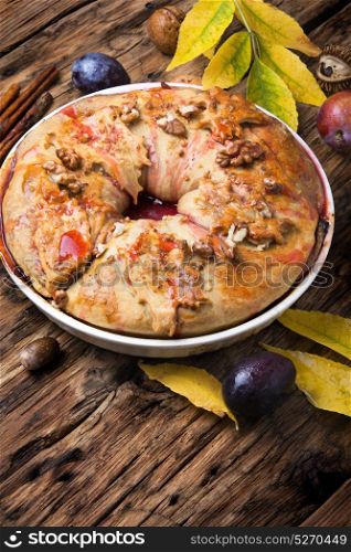 strudel with plum. Plum strudel on background with autumn leaves