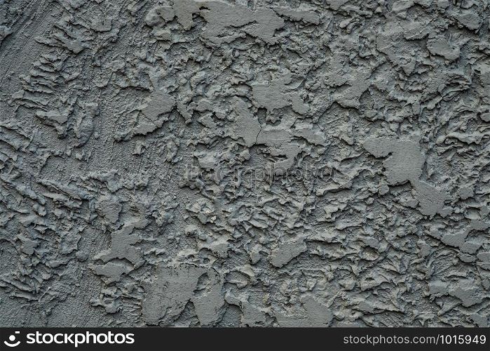 Stucco cement wall texture background in dark grey color paint.