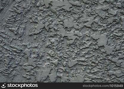 Stucco cement wall texture background in dark grey color paint.