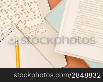 Student&acute;s desk laptop, pen and notepad school supplies