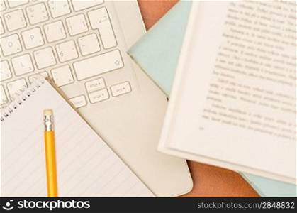 Student&acute;s desk laptop, pen and notepad school supplies