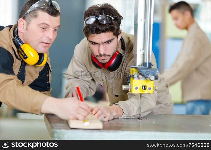 student and teacher sawing wood