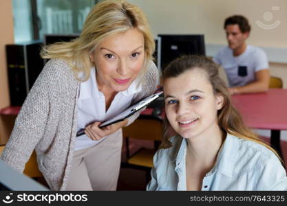 student and teacher sitting at table