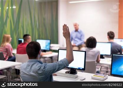 student answering a question in classroom, mature teacher and students in computer lab classroom