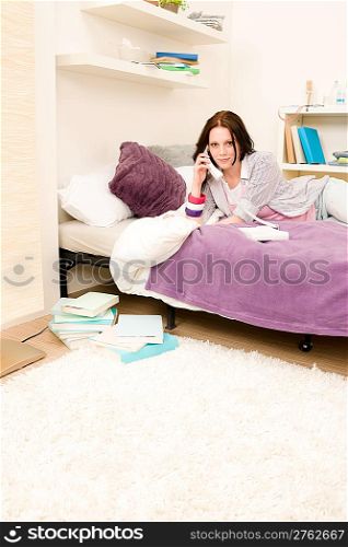 Student apartment - young girl speaking on phone lying on bed