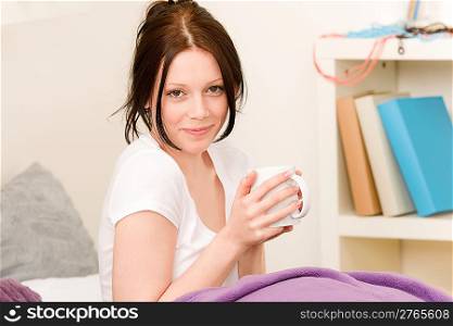 Student apartment - Young student girl drink coffee in bed