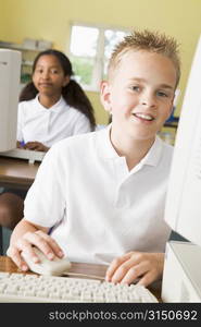 Student at computer terminal with student in background (selective focus)