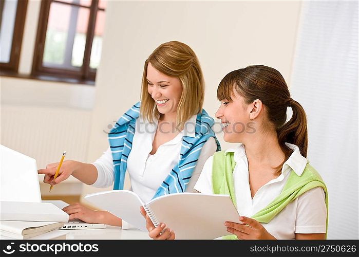 Student at home - two happy woman with laptop and book study