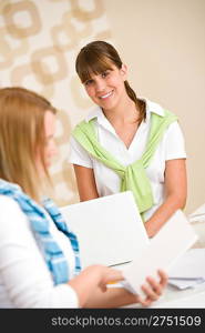 Student at home - two smiling woman with book and laptop study