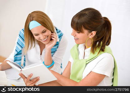 Student at home - two young woman study together with book