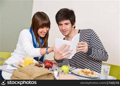 Student cafeteria - Teenagers having lunch break, holding book