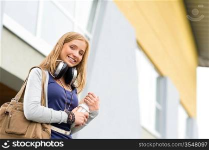 Student carrying books to school headphones happy young teenage girl