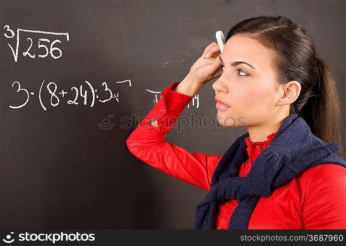 student dirl at a blackboard during a lesson thinking how to solve a math problem