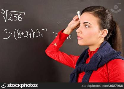 student dirl at a blackboard during a lesson thinking how to solve a math problem