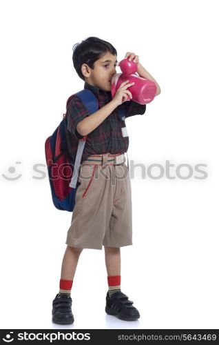 Student drinking water from water bottle against white background