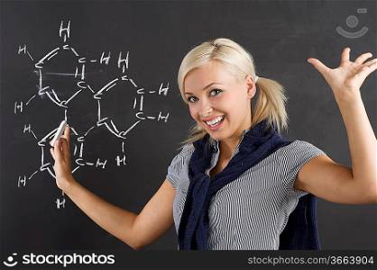 student enjoing for her chemical lesson in front of blackboard