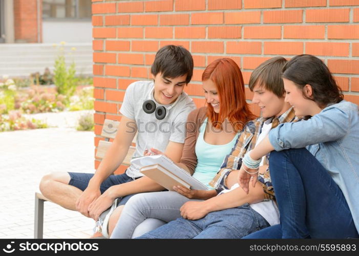 Student friends studying together sitting outside college campus discussing notes