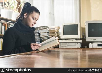 Student girl in a library. Looking at book