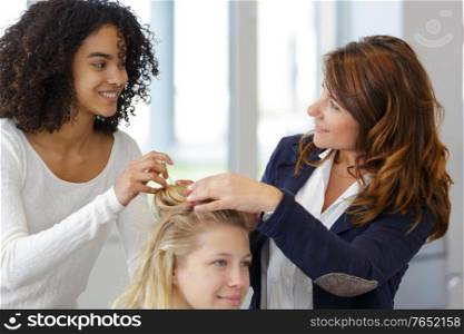 student girl in hairdressing learning how to cut hair