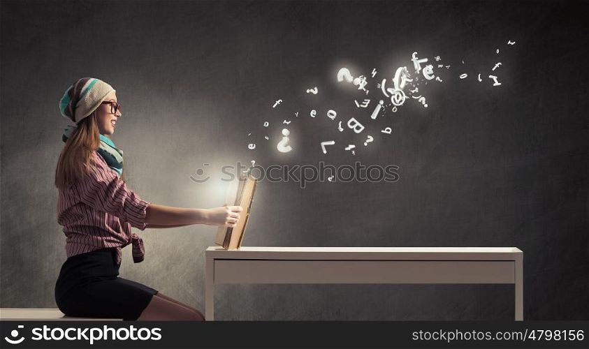 Student girl read book. Hipster girl in glasses sitting at table and reading book