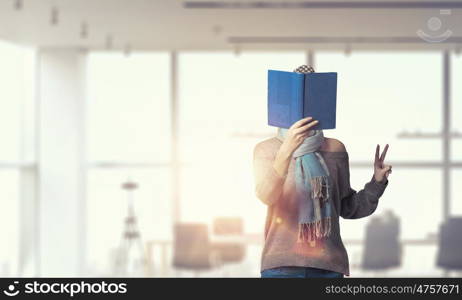 Student girl with book in hands. Young hipster girl with opened book in hands