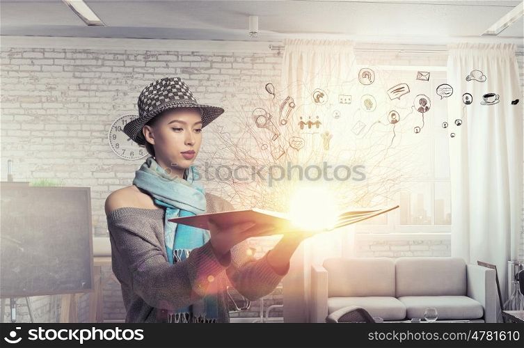 Student girl with book in hands. Young hipster girl with opened book in hands