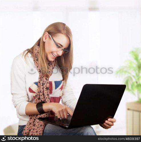 Student girl working at home, preparing to exam in the university, with pleasure typing something on the laptop, gladly receives knowledge on the Internet
