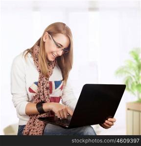 Student girl working at home, preparing to exam in the university, with pleasure typing something on the laptop, gladly receives knowledge on the Internet