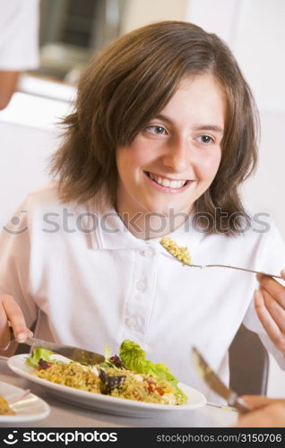 Student in cafeteria eating lunch (selective focus)