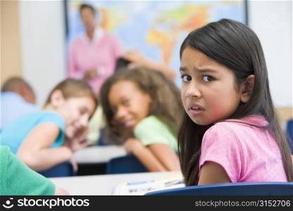 Student in class being bullied by students in background (selective focus)
