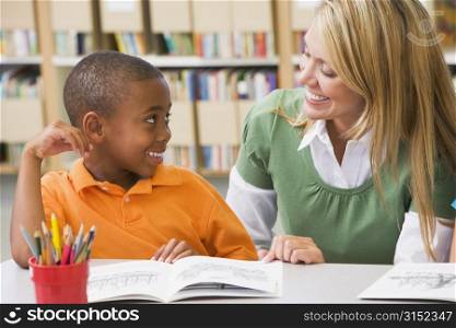 Student in class reading with teacher