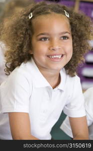 Student in class sitting on floor smiling (selective focus)