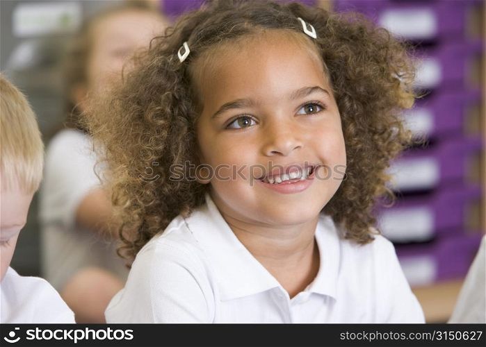 Student in class sitting on floor with students in background (selective focus)