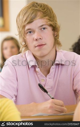 Student in class taking notes (selective focus)