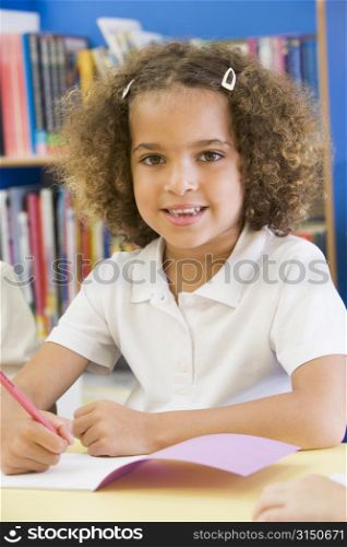 Student in class writing in notebook (selective focus)
