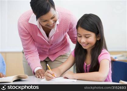 Student in class writing with teacher