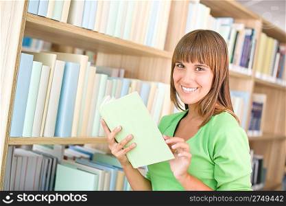 Student in library - cheerful woman choose book from bookshelf