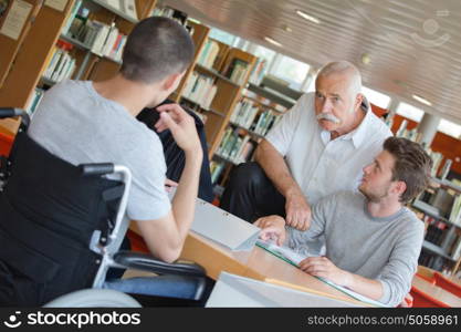 student in wheelchair friend and teacher at the library