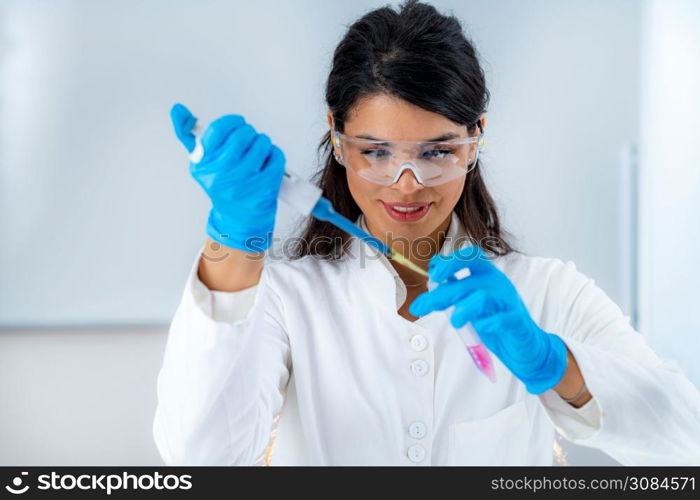 Student in White Coat, Working in Research Laboratory Using Micro Pipette and Test Tube