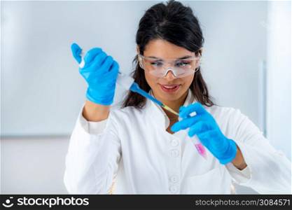 Student in White Coat, Working in Research Laboratory Using Micro Pipette and Test Tube